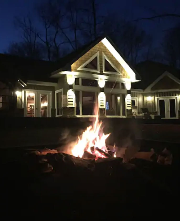 exterior cabin at night near campfire