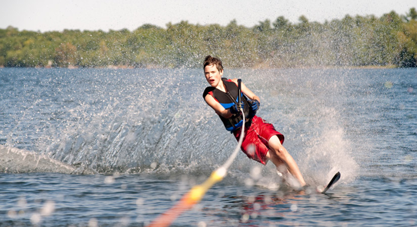 Teenage boy waterskiing on a lake